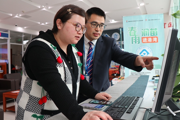 在三峽銀行綦江支行銀行，工作人員輔導(dǎo)市民韓女士網(wǎng)上申報(bào)納稅。李奕萱攝