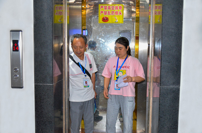 牌樓街道大河溝社區(qū)，物業(yè)長(zhǎng)、樓棟長(zhǎng)排查居民反映的電梯安全問(wèn)題。付作僑攝