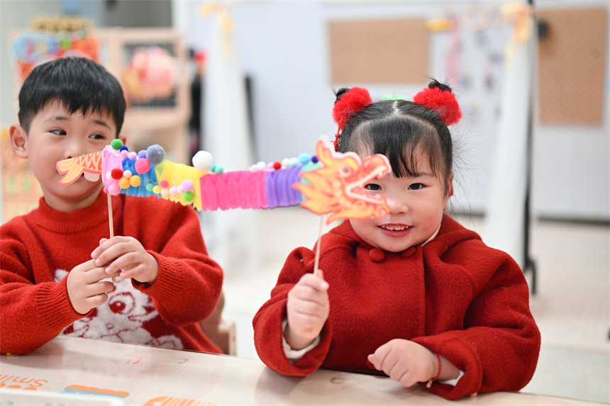 小朋友展示制作的手工翻花龍。郭旭攝