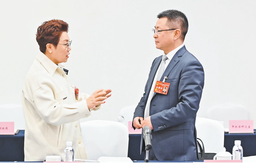 　1月22日，市人大代表在會議間隙就引進AI機器人智能駕培系統(tǒng)的建議展開討論。記者 齊嵐森 攝/視覺重慶