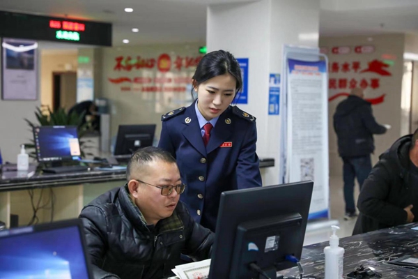 在梁平區(qū)辦稅服務(wù)廳電子稅務(wù)局辦理專區(qū)，稅務(wù)人員輔導(dǎo)企業(yè)辦稅人員線上辦稅。唐曉敏攝