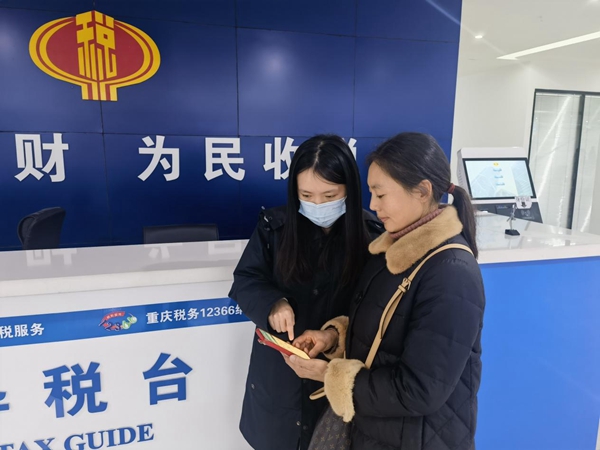 武隆區(qū)稅務(wù)人員輔導(dǎo)群眾在手機(jī)上辦理社保業(yè)務(wù)。侯東攝