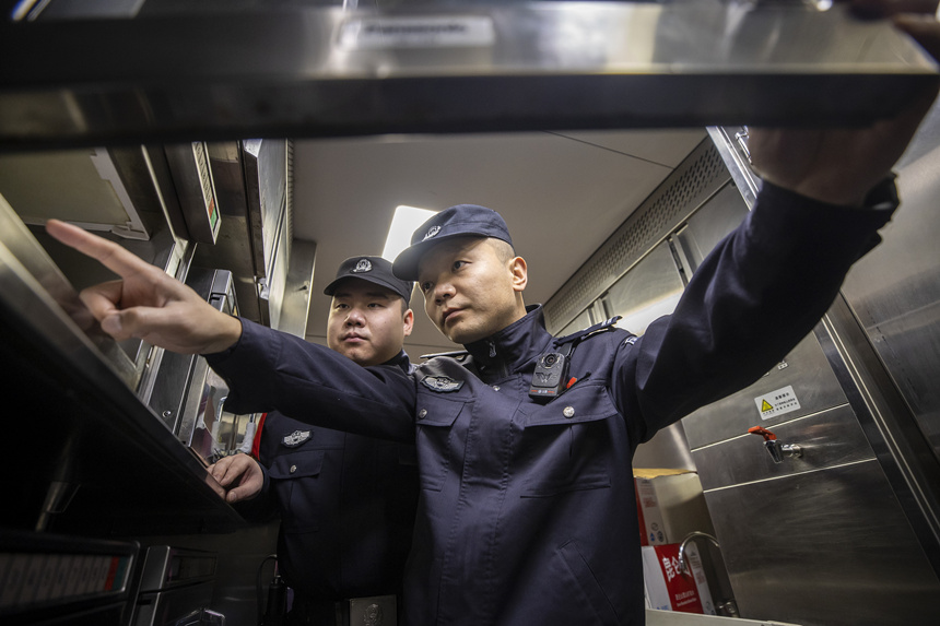 彭聰（右一）在乘警的配合下，對(duì)列車(chē)電器設(shè)備進(jìn)行檢查。胡勇攝