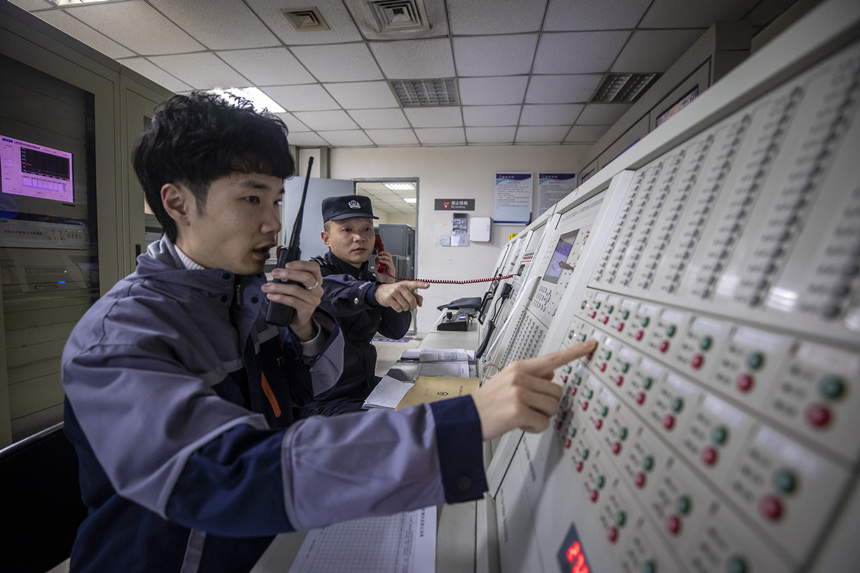 彭聰（右一）在重慶北站消防控制室工作人員的配合下，對(duì)車(chē)站消防信號(hào)設(shè)備進(jìn)行測(cè)試。胡勇攝