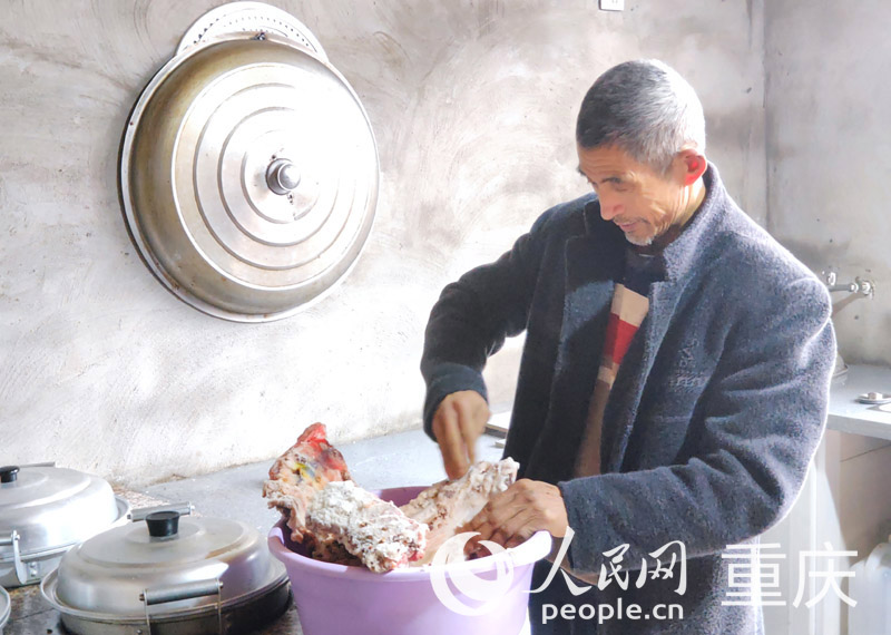 佘中華在新家廚房制作腌肉。人民網 陳琦攝