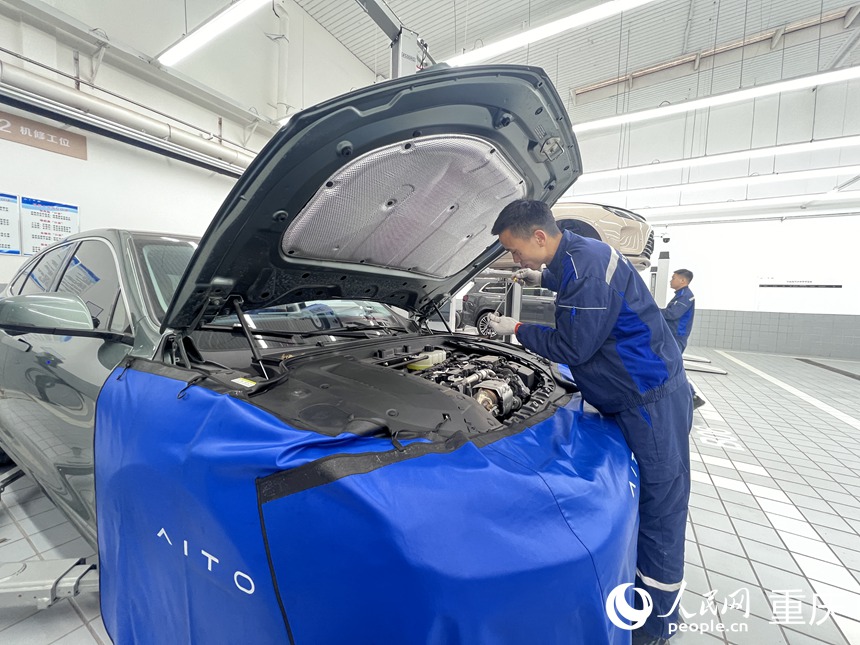 張甲震在為新能源汽車做保養(yǎng)。人民網(wǎng)記者 胡虹攝
