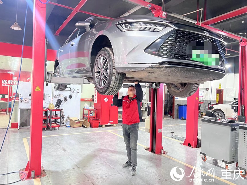 冉清兵在檢查新能源汽車底盤。人民網(wǎng)記者 胡虹攝