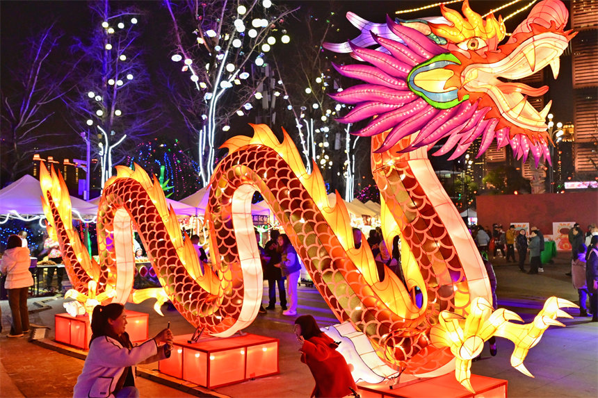 游客在南岸區(qū)南濱路鐘樓廣場(chǎng)賞燈拍照。郭旭攝