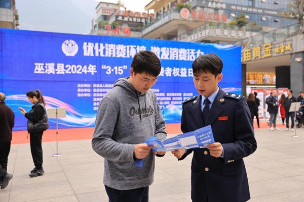 3月15日，在巫溪縣水園商城，稅務(wù)人員正為市民講解發(fā)票維權(quán)相關(guān)內(nèi)容。肖镕攝