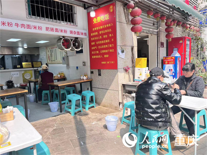 “免費(fèi)吃飯”的告示就貼在餐館入口右邊的墻上，紅底黃字十分醒目。人民網(wǎng) 馮文彥 攝