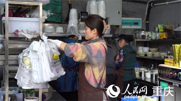 中午時(shí)分，店主何女士正在莽著給顧客備餐。人民網(wǎng) 劉祎攝