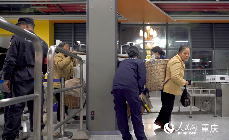 軌道四號(hào)線石船站工作人員幫助菜農(nóng)果農(nóng)們有序進(jìn)站。人民網(wǎng)記者 劉祎攝