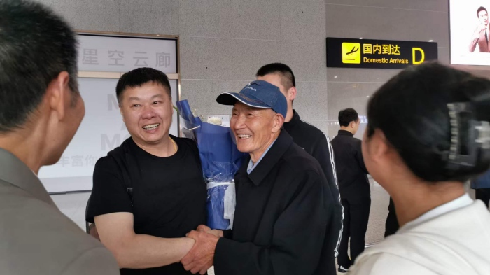 唐啟明在機(jī)場(chǎng)與親人共敘親情。重慶合川區(qū)公安分局供圖