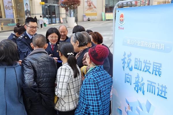 近日，在城口縣名豪廣場，稅務(wù)人員為群眾發(fā)放社保宣傳手冊。重慶市稅務(wù)局供圖