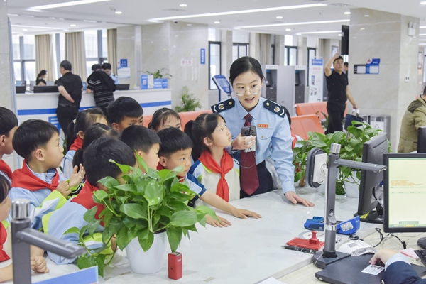 在奉節(jié)縣辦稅服務(wù)廳，稅務(wù)人員帶領(lǐng)“小小稅務(wù)體驗師”參觀辦稅窗口，引導(dǎo)同學們“沉浸式”體驗稅費服務(wù)。蔡仲垚攝