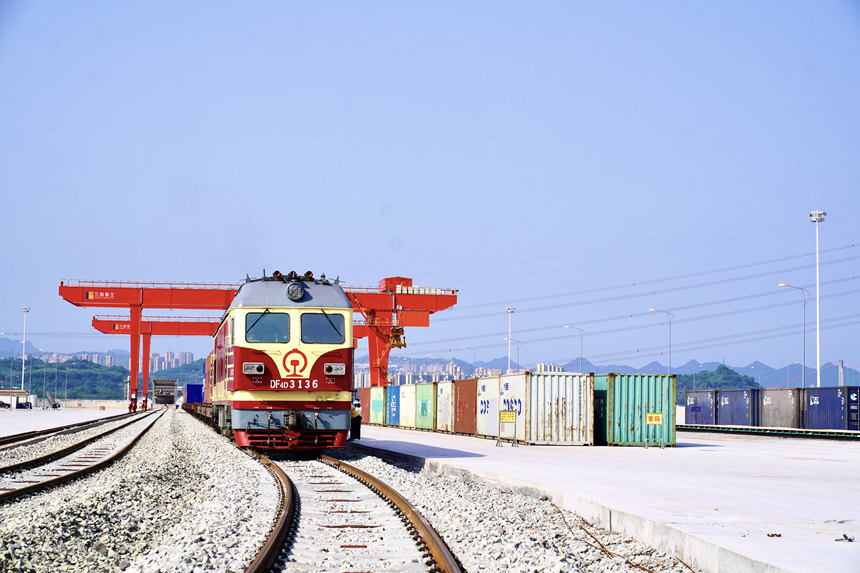 4月28日，重慶涪陵龍頭港，一列搭載著精己二酸、聚酯切片等貨物的西部陸海新通道集裝箱班列緩緩駛出。涪陵車(chē)務(wù)段供圖
