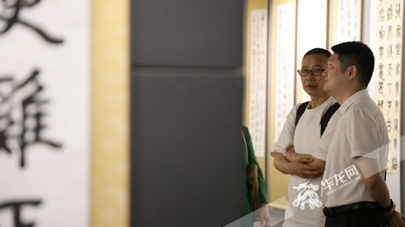 書畫展觀眾認(rèn)真觀賞作品。華龍網(wǎng)記者 李燊 攝