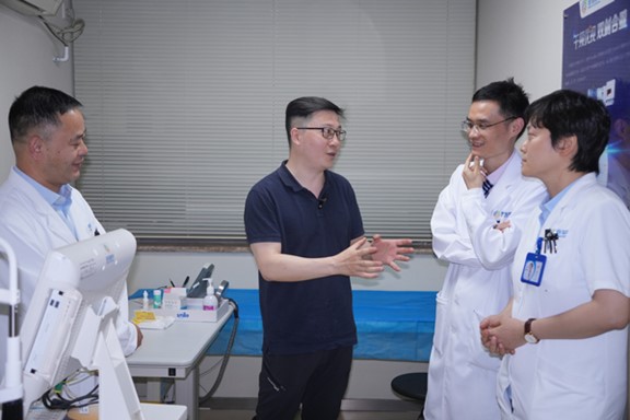 何勇（左二）與醫(yī)生探討科AI的應(yīng)用。重慶普瑞眼科醫(yī)院供圖