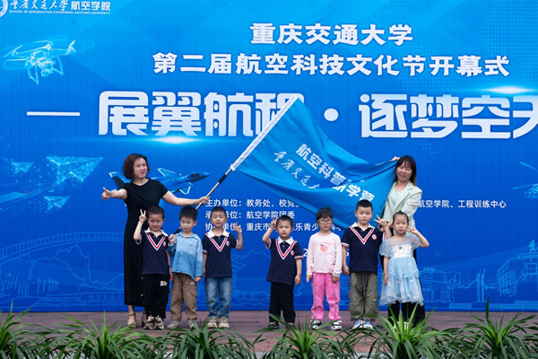 該校航空學(xué)院黨委書(shū)記舒琳為來(lái)自雙福巴蜀實(shí)驗(yàn)幼兒園的小朋友代表授旗。重慶交通大學(xué)供圖