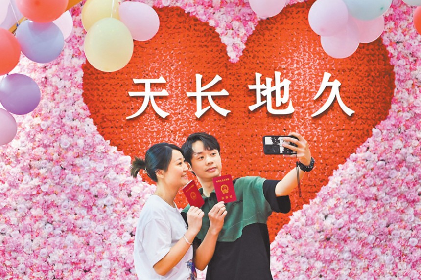 5月20日，渝北區(qū)婚姻登記處，新人正在拍照留影。當(dāng)日，在該婚姻登記處，一對(duì)對(duì)新人排起了長(zhǎng)隊(duì)。婚姻登記處采取電話預(yù)約、增加結(jié)婚登記窗口等舉措，保障結(jié)婚登記工作的順利開展。首席記者 龍帆 攝/視覺(jué)重慶