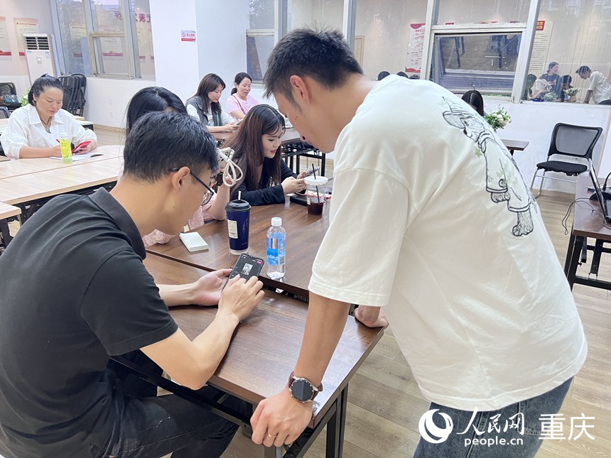 龍門夜校老師正在給青年學(xué)員講解視頻剪切技巧。 人民網(wǎng)記者 胡虹攝