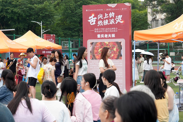 學(xué)生在活動(dòng)現(xiàn)場(chǎng)一邊品嘗美食，一邊尋找工作。秦廷富攝