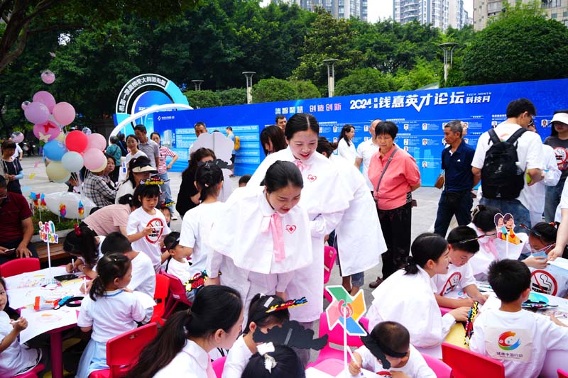 在醫(yī)護人員及家長帶領(lǐng)下，小朋友們圍繞控?zé)熤黝}畫畫。實習(xí)生趙鑫攝