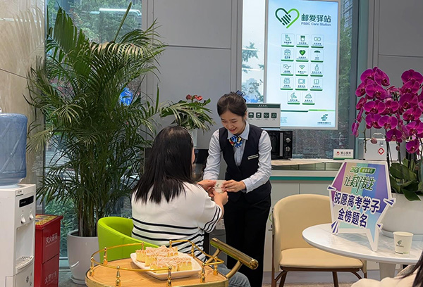 “郵愛驛站”工作人員為送考家長端上熱水。郵儲銀行重慶分行供圖