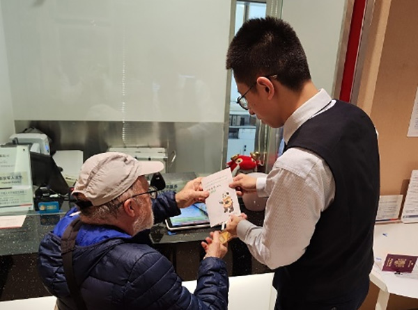 工作人員為外籍來渝人員講解相關(guān)業(yè)務(wù)辦理流程。浦發(fā)銀行重慶分行供圖