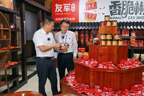 余家友（左）向工行工作人員介紹企業(yè)食品。戚馨月 攝