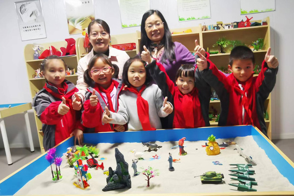 楊雪梅書記（左一）指導學生參與心理沙盤體驗活動。四牌坊小學供圖