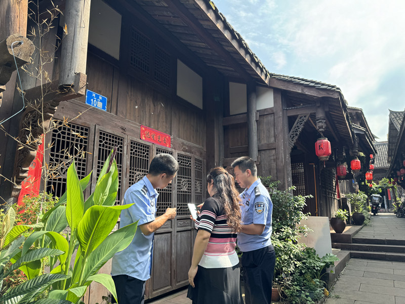 潼南雙江古鎮(zhèn)社區(qū)民警指導(dǎo)群眾掃碼應(yīng)用。潼南區(qū)公安局供圖