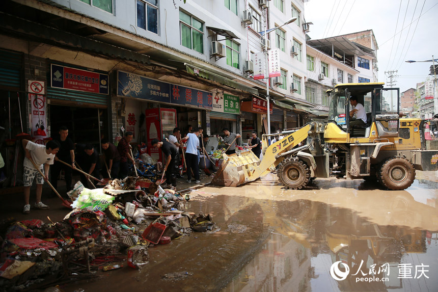 7月12日，志愿者和群眾合力清理仁沙鎮(zhèn)場鎮(zhèn)的淤泥和雜物。人民網(wǎng)記者 劉政寧攝
