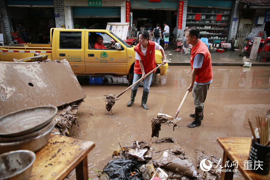 志愿者清理仁沙鎮(zhèn)場鎮(zhèn)的淤泥和雜物。人民網(wǎng)記者 劉政寧攝