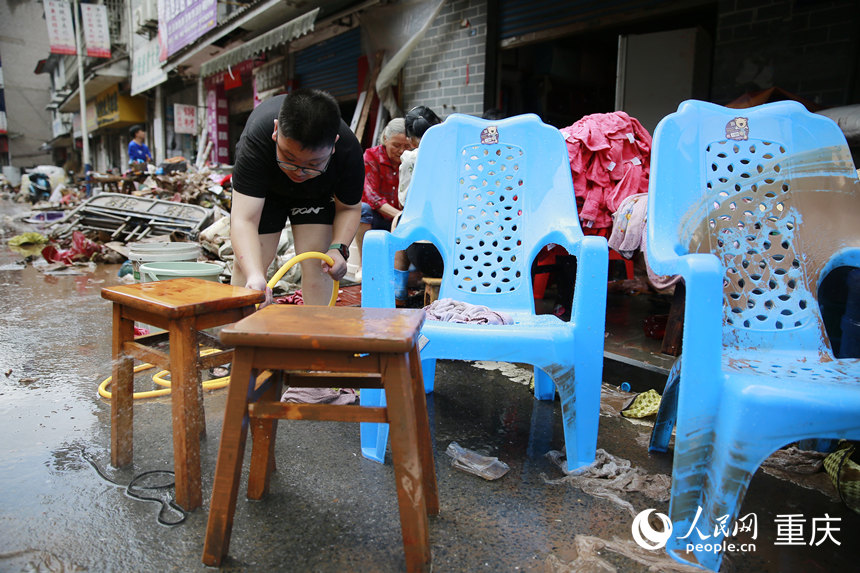 洪水消退后，居民正在清洗被洪水浸過的物品。人民網(wǎng)記者 劉政寧攝