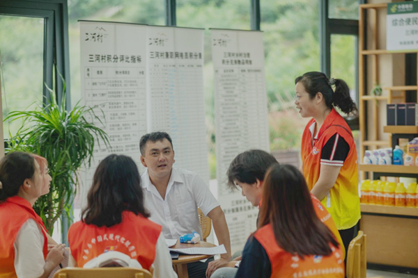 實(shí)踐團(tuán)成員與三河村工作人員交談。彭聰攝