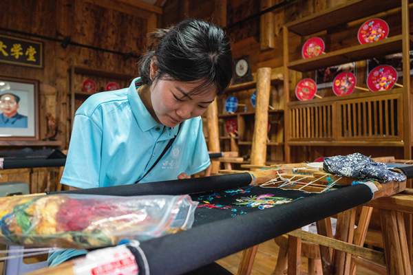 小分隊(duì)成員在苗繡工坊體驗(yàn)繡制酉州苗繡。西南大學(xué)供圖