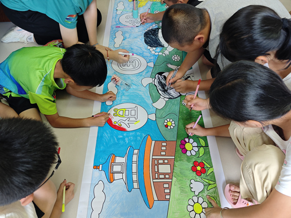 服務(wù)團(tuán)成員與孩子們一起手繪表白祖國。重慶郵電大學(xué)供圖