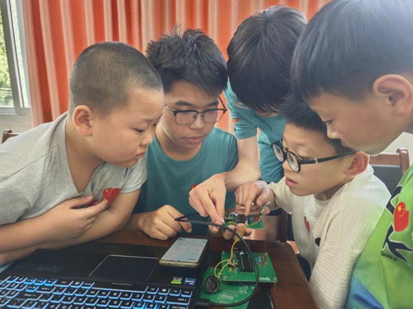 服務(wù)團(tuán)成員現(xiàn)場展示“光電精靈”。重慶郵電大學(xué)供圖