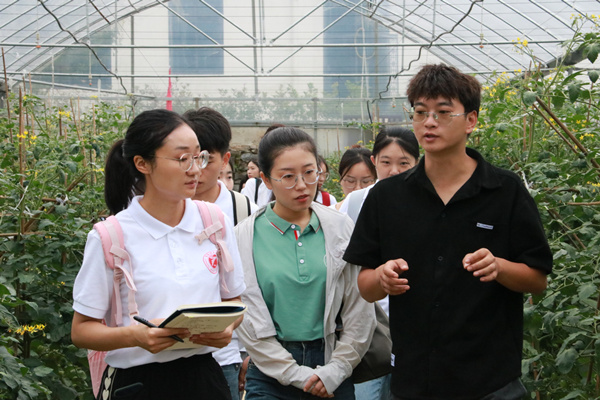 重慶市農(nóng)科院研究員余清陽帶領(lǐng)實(shí)踐團(tuán)參觀蔬菜研究所種植基地。重慶理工大學(xué)供圖