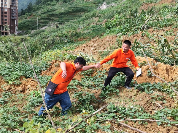 《跋涉》。6月29日，107地質(zhì)隊(duì)的駐守地質(zhì)工程師陳虹洲在彭水巡查雨后的地災(zāi)點(diǎn)時(shí)深陷泥潭，同事王發(fā)英搭手拽他脫離“困境”。李明亮攝