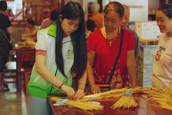 草編匠人教團隊成員編織草帽。張好攝