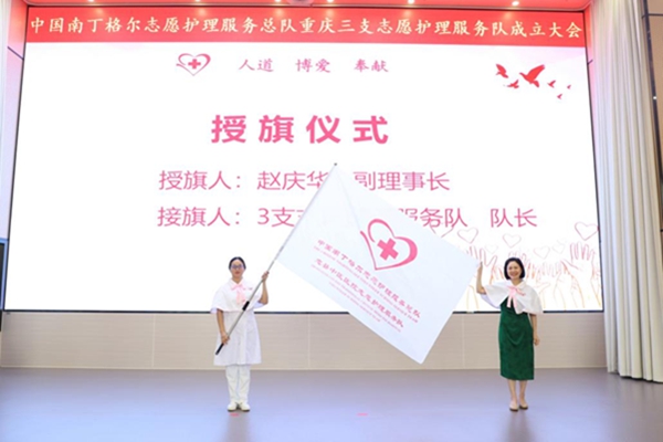 中國(guó)南丁格爾志愿護(hù)理服務(wù)總隊(duì)副理事長(zhǎng)趙慶華（右）為服務(wù)隊(duì)授旗。李道國(guó)攝