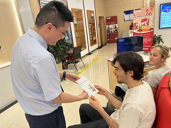 為外籍來(lái)華人員發(fā)放雙語(yǔ)宣傳折頁(yè)。浦發(fā)銀行重慶分行供圖