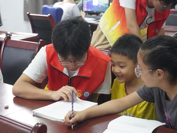 志愿者輔導(dǎo)孩子完成作業(yè)。重慶財(cái)經(jīng)學(xué)院供圖