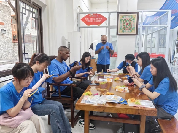 實(shí)踐團(tuán)成員在羌繡文化傳習(xí)所學(xué)習(xí)刺繡。重慶大學(xué)供圖