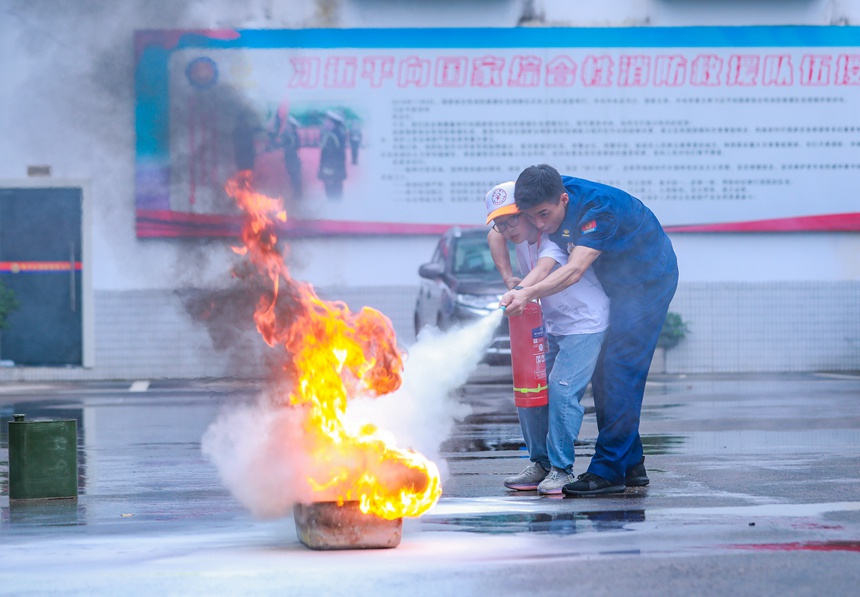 消防員指導小朋友用滅火器救火。梁平區(qū)青少年活動中心供圖