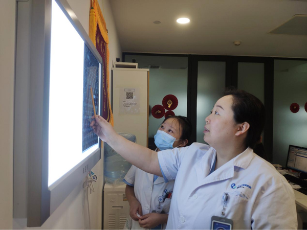 張朝梅查看患者的檢查報(bào)告。重慶仁品耳鼻喉醫(yī)院供圖