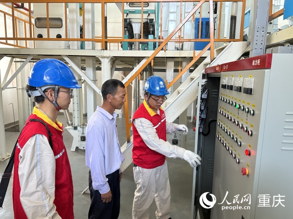 供電所工作人員上門檢查小米加工廠用電情況。人民網(wǎng)記者 劉政寧攝