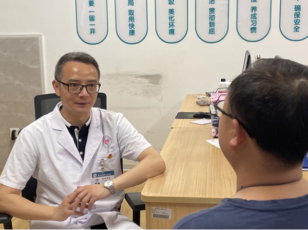 陳黎明正在與患者溝通。重慶市精神衛(wèi)生中心供圖